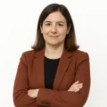 Ana Gómez, autora de El Espectro, posando con los brazos cruzados y expresión confiada sobre fondo blanco
